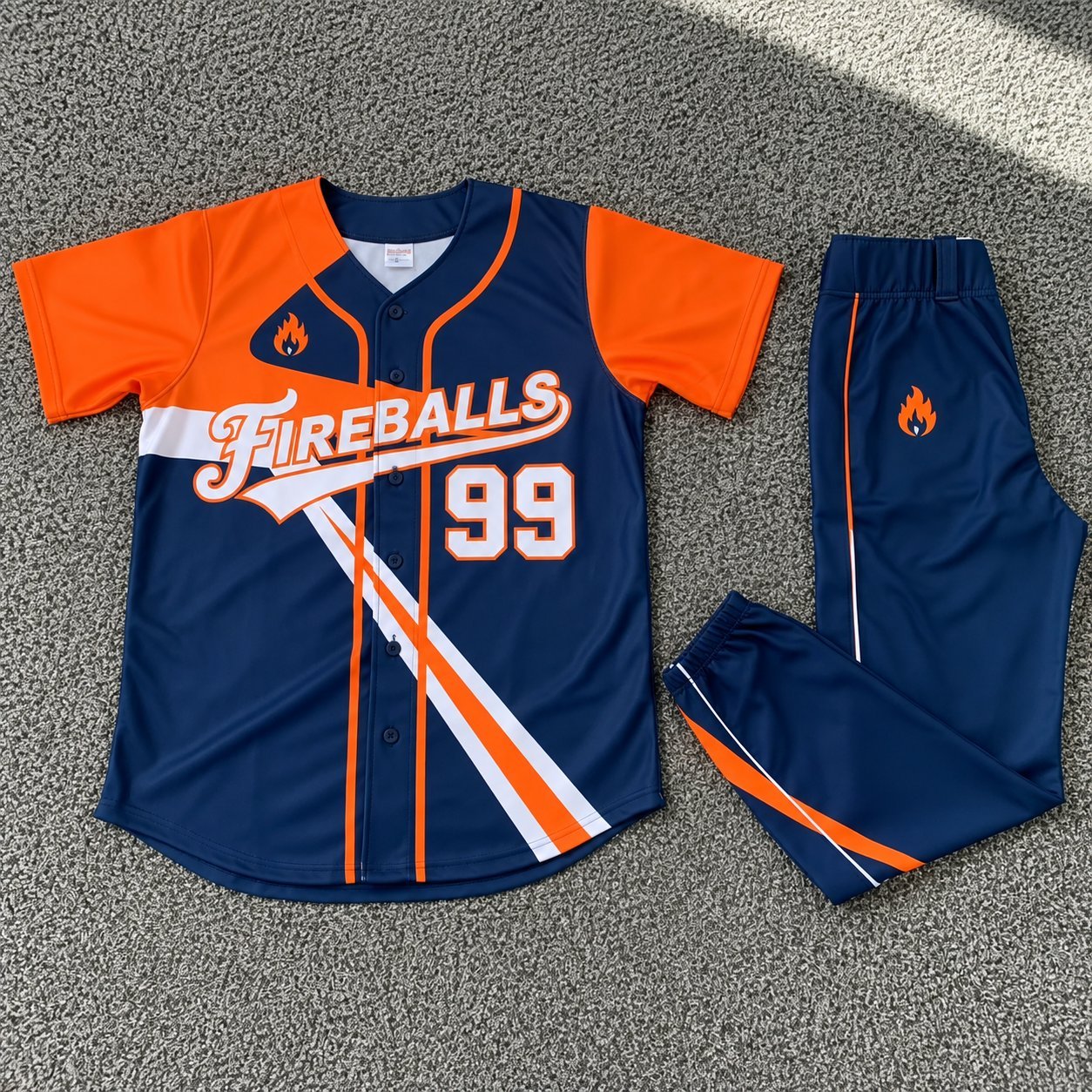 Navy and orange custom softball jersey number 99 with Fireballs script and matching pants.