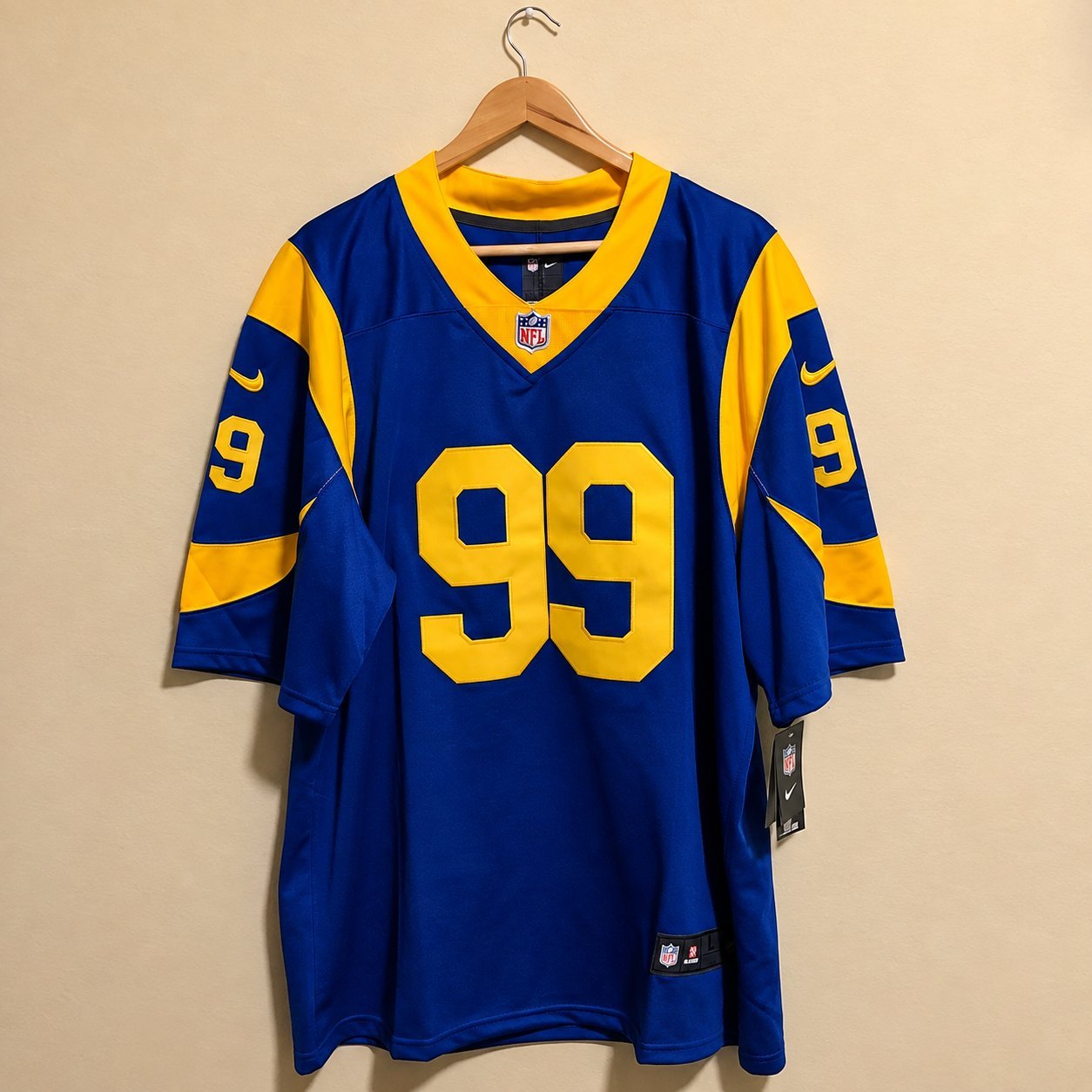 Royal blue throwback football jersey with yellow sleeves hanging on wall