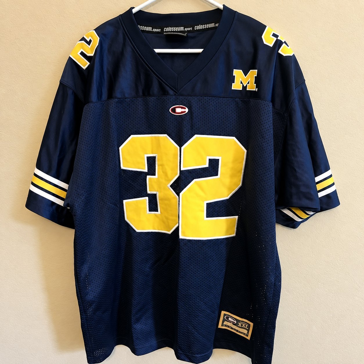 Navy blue throwback football jersey with yellow M crest and number 32