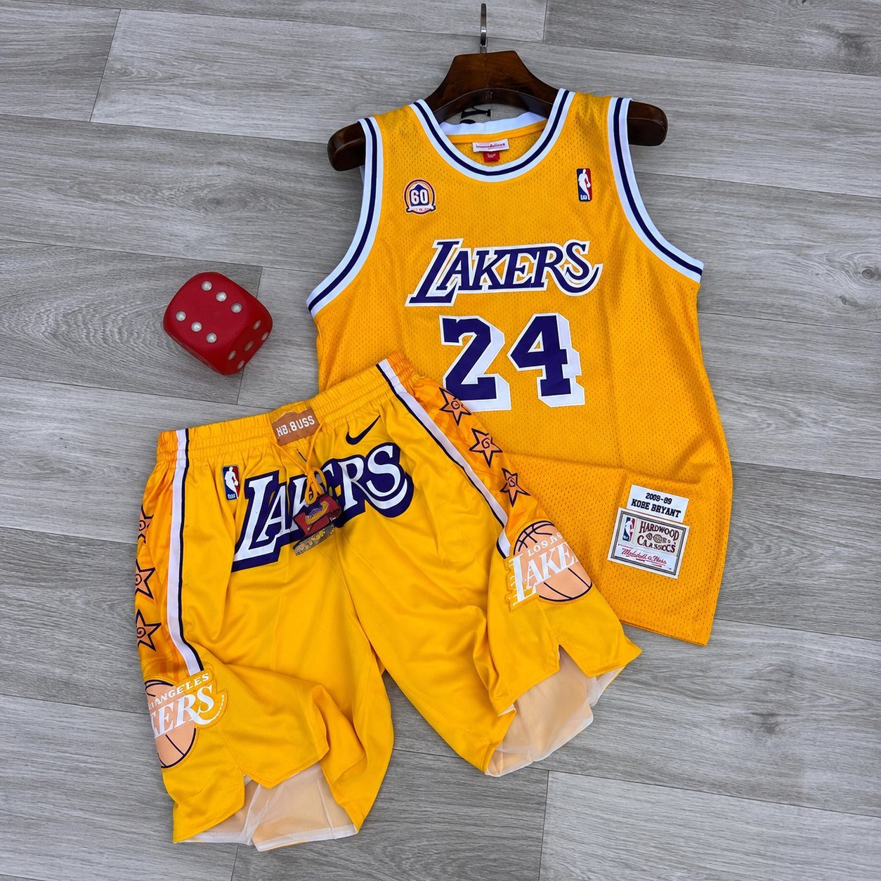 Yellow Los Angeles Lakers 1996-era Kobe Bryant #24 throwback jersey hanging with matching shorts and a red dice