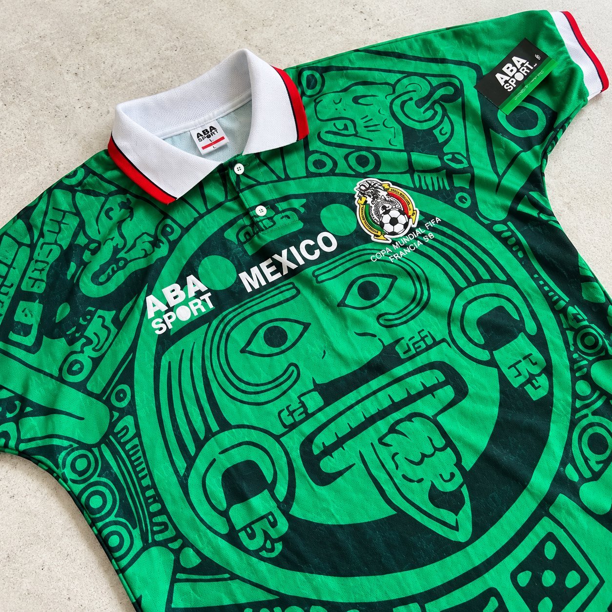ABA Sport Mexico 1998 replica — flat lay showing Aztec Sun Stone pattern